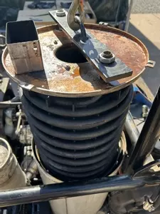 Lifting damaged heating coil out of Nilfisk Contractor diesel pressure washer boiler during repair.